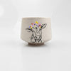Artsy Ems Designs white ceramic Artisan Cow Cup features a handcrafted look with a black line cow wearing a colorful flower crown—perfect for whimsical home décor and displayed on a plain white surface.
